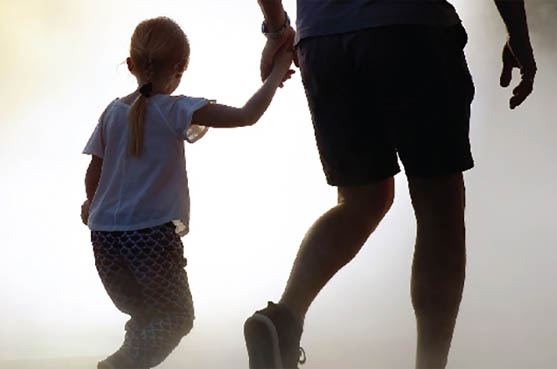 young girl holder her father’s hand