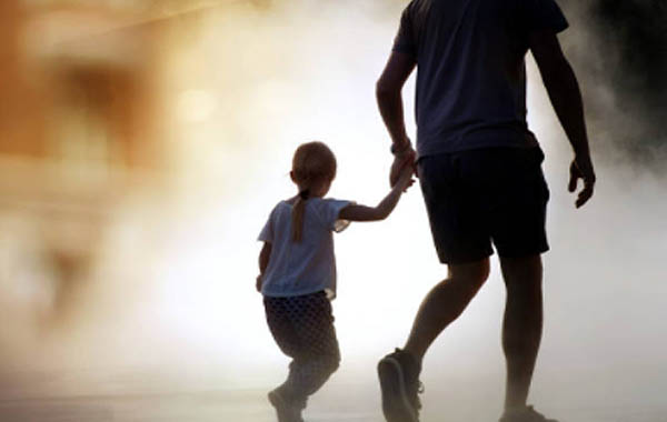 young girl holder her father’s hand